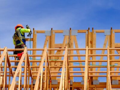 Construction workers working on new home or restidential building with wooden beams framed and sky